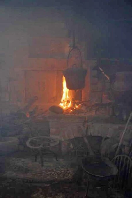 ein Feuer lodert in der spätmittelalterlichen Rauchküche